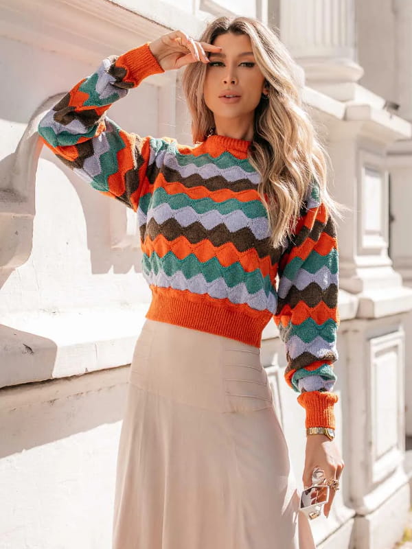 Blusa de frio de tricot: modelo com uma blusa de tricot feminina cropped listrada laranja.