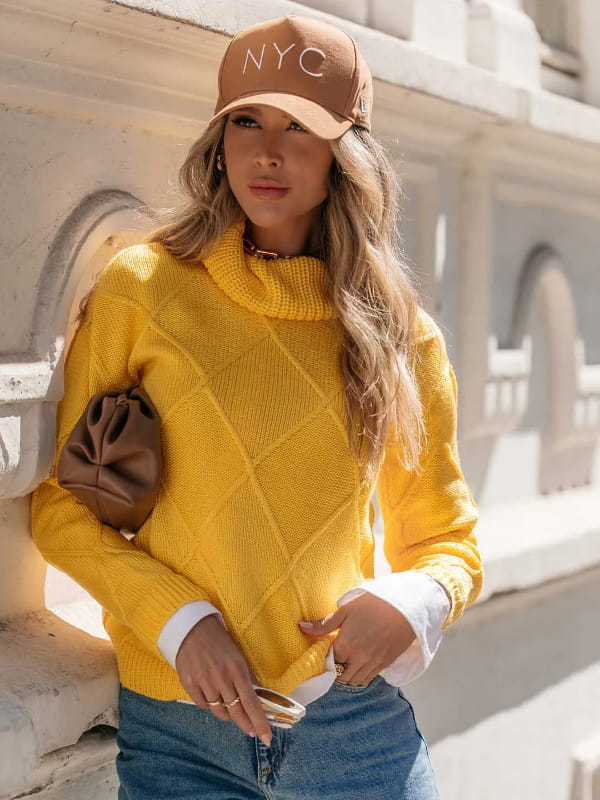 No inverno as pessoas ficam mais elegantes: modelo com uma blusa de tricot feminina gola alta amarela.