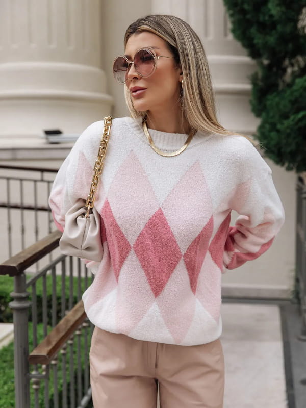Looks de inverno para trabalhar: modelo com uma blusa de tricot feminina losango rosa e off white.
