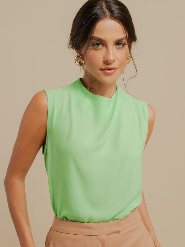 Blusa verde social feminina: modelo vestindo uma blusa de crepe com pregas no ombro.