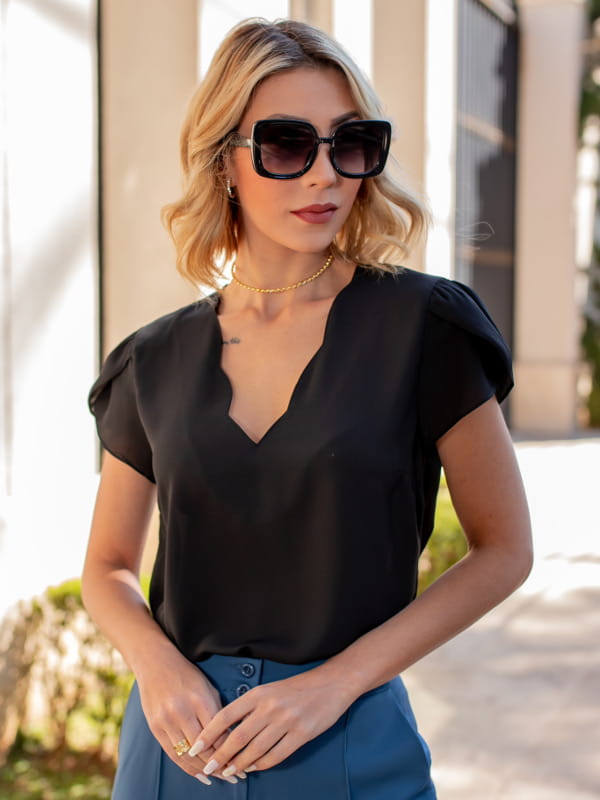 Blusas femininas da moda: modelo vestindo uma blusa de crepe preta com decote nuvem.