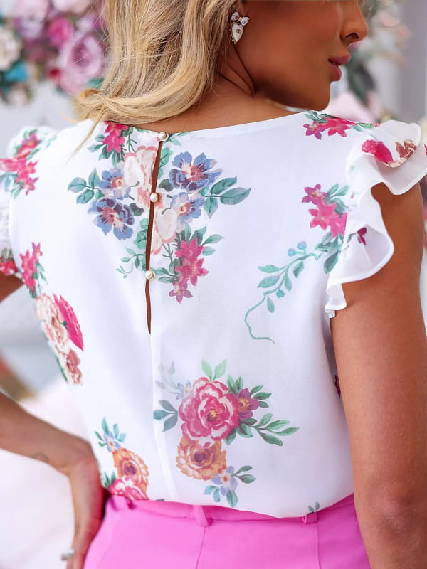 Blusas femininas delicadas: modelo vestindo uma blusa floral com babados - costas.