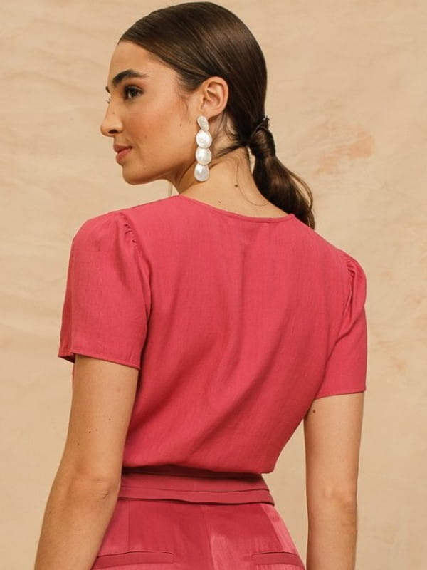 Blusa de linho feminina: modelo vestindo uma blusa de linho rosê mostrando as costas.