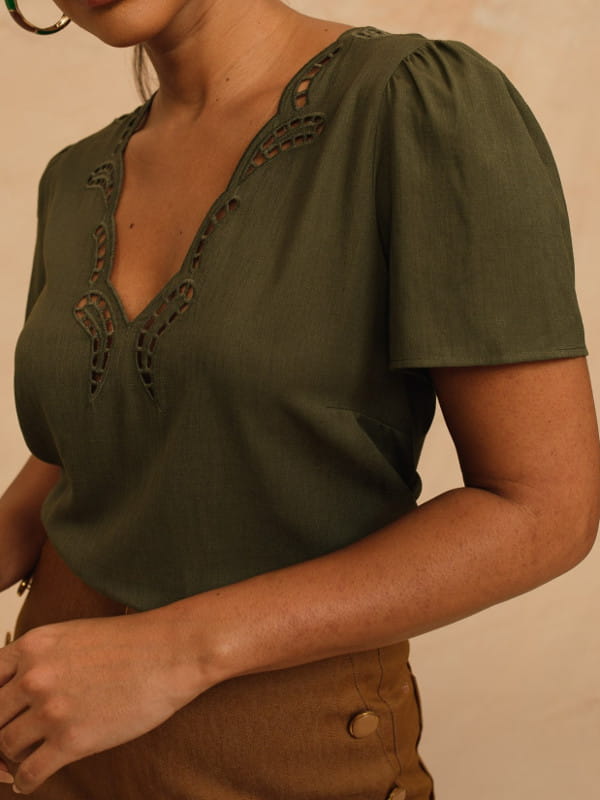 Blusa de linho feminina: modelo vestindo uma blusa de linho verde com bordado e decote V.