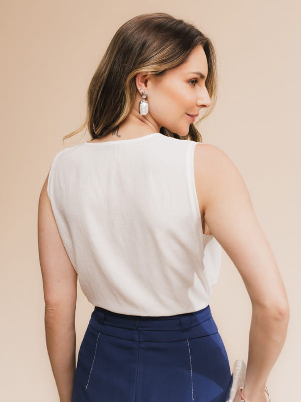 Blusa de viscose lisa feminina: modelo vestindo uma regata com decote V na cor branca com uma calça jeans - costas.