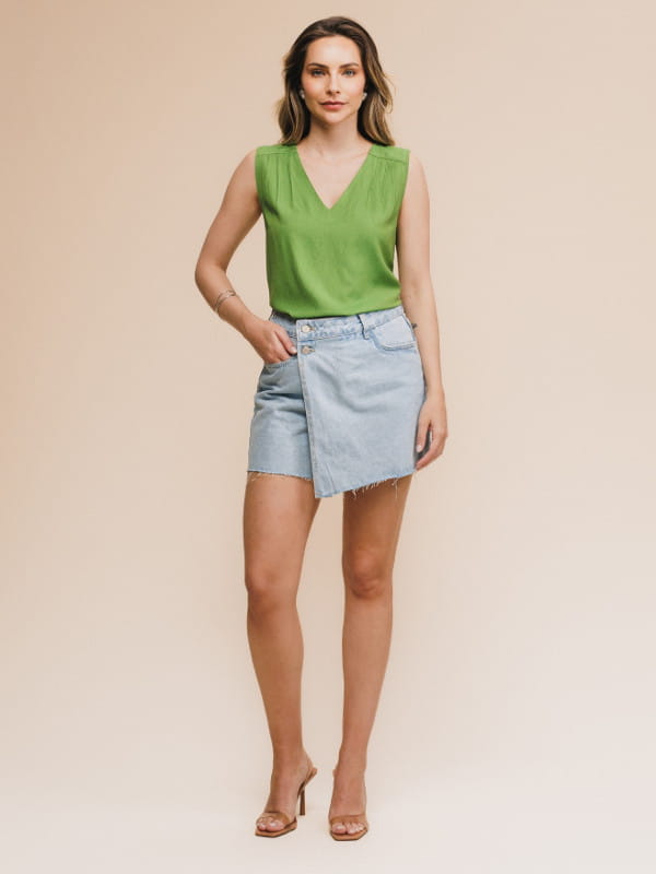 Blusa de viscose lisa feminina: modelo vestindo uma regata com decote V na cor verde com uma calça jeans - look.