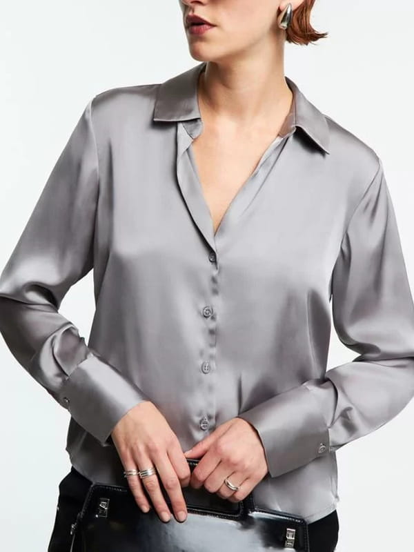 Blusa social feminina: modelo vestindo uma camisa em cetim com recortes e caimento leve prata - detalhes.