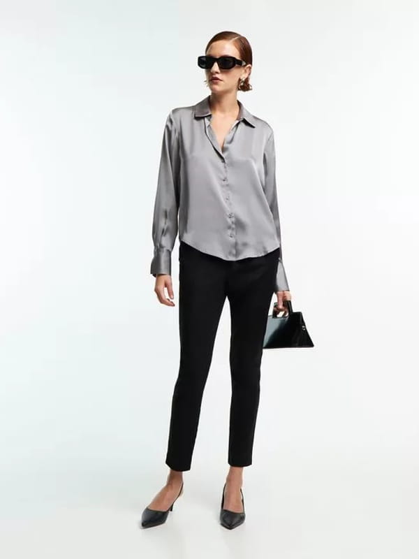 Blusa social feminina: modelo vestindo uma camisa em cetim com recortes e caimento leve prata - look.