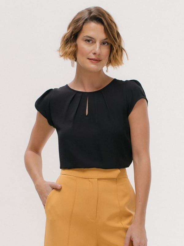 Blusa social feminina de crepe: modelo vestindo uma blusa de crepe preta com detalhe gota no decote.