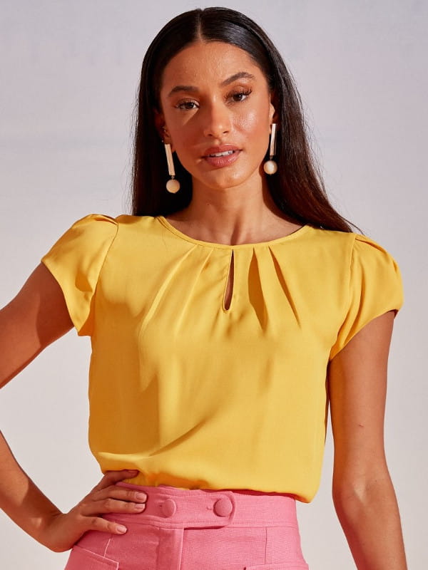 Blusa social feminina: modelo vestindo uma blusa de crepe amarela com detalhe gota.