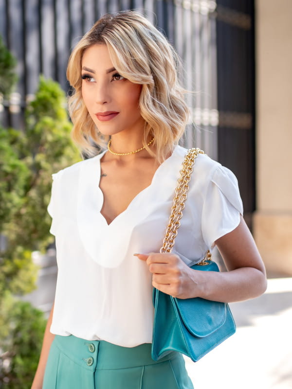 Blusa social feminina de crepe: Modelo vestindo uma blusa de crepe decote V nuvem na cor branca.