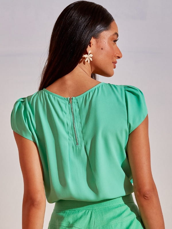 Blusa social feminina de crepe: modelo vestindo uma blusa com detalhe gota na cor verde claro - costas.