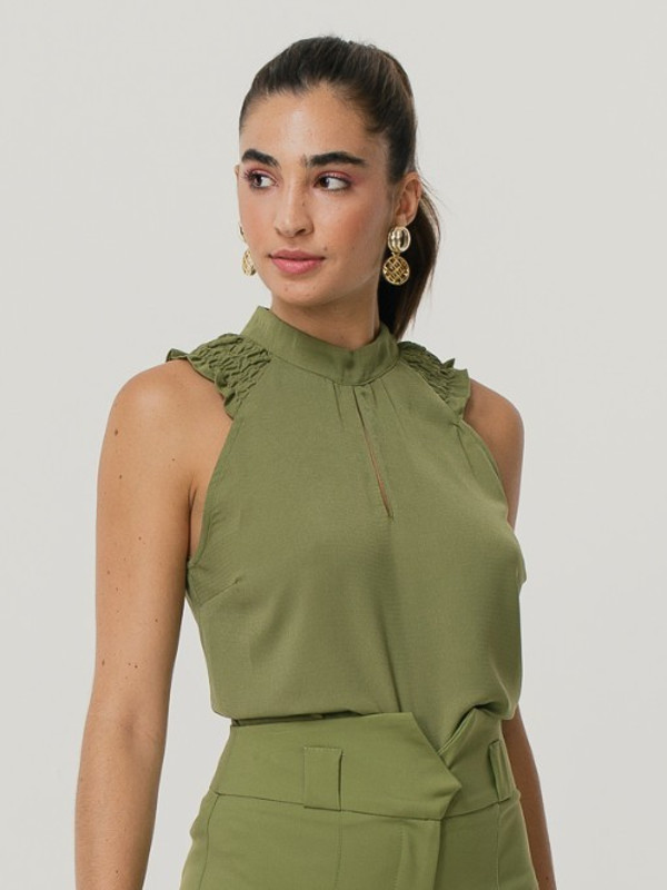 Blusa social feminina: modelo vestindo uma blusa de crepe com detalhe lastex verde.