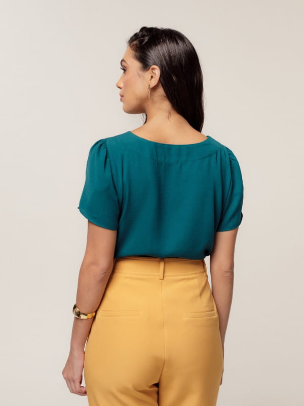 Blusa Unique Chic: modelo vestindo uma blusa de crepe texturizado decote redondo verde - costas.