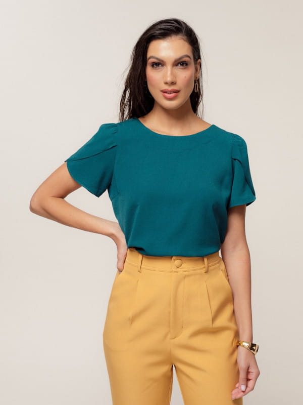 Blusa Unique Chic: modelo vestindo uma blusa de crepe texturizado decote redondo verde.