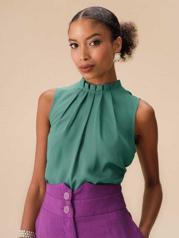 Blusa verde social feminina: modelo vestindo uma blusa de crepe básica com pregas cor verde sálvia.