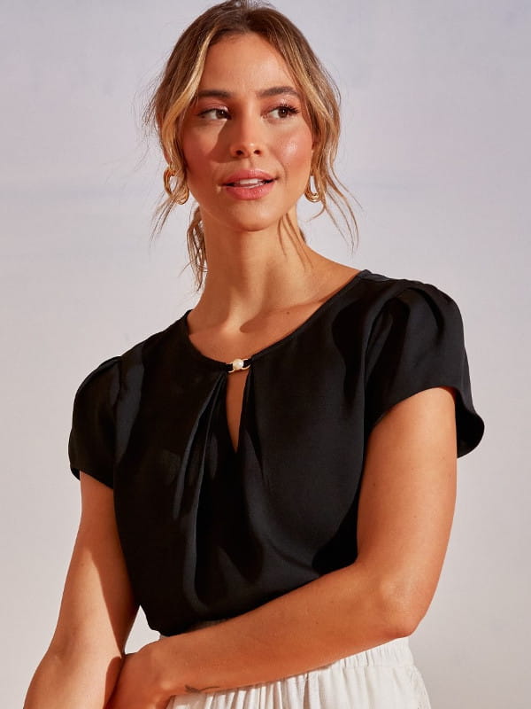 Blusas femininas 2022: modelo vestindo uma blusa de crepe com decote e pérola preta.