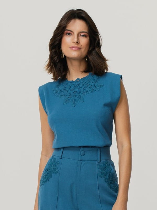Blusas femininas para trabalhar: modelo vestindo uma blusa de linho com renda no decote azul.