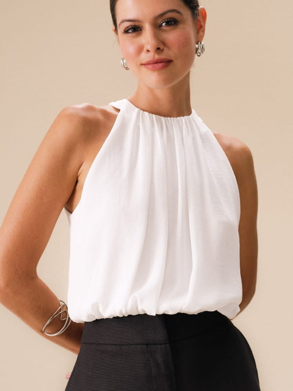 Modelos de blusas femininas: modelo vestindo uma regata de crepe texturizado cropped off white.