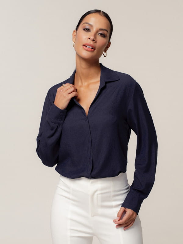 Blusas femininas 2023: modelo vestindo uma camisa em viscolinho com botões resinados azul marinho.