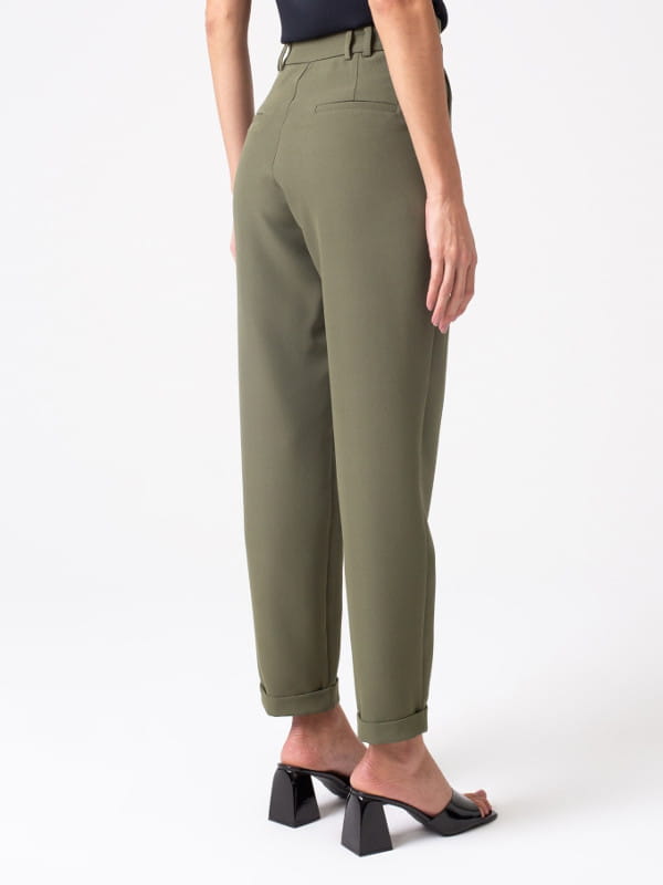Calça alfaiataria feminina: modelo vestindo uma calça feminina alfaiataria com elastano e passantes duplos verde - costas.