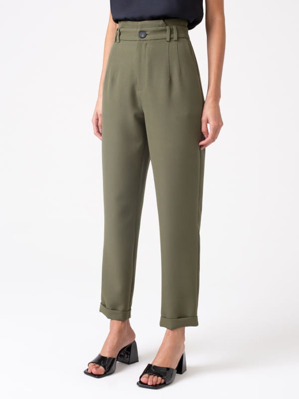 Calça alfaiataria feminina: modelo vestindo uma calça feminina alfaiataria com elastano e passantes duplos verde - perfil.