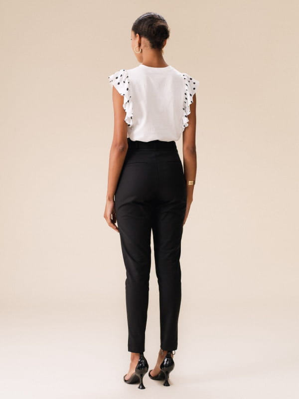 Calça alfaiataria feminina: modelo vestindo uma calça alfaiataria feminina skinny em sarja - costas.