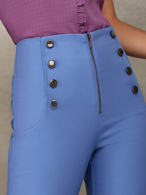 Calça skinny feminina: detalhe de uma calça skinny na cor azul com botões frontais.