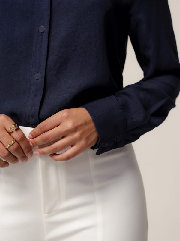 Camisa manga longa feminina: modelo vestindo uma camisa em viscolinho com botões resinados azul marinho - detalhes.