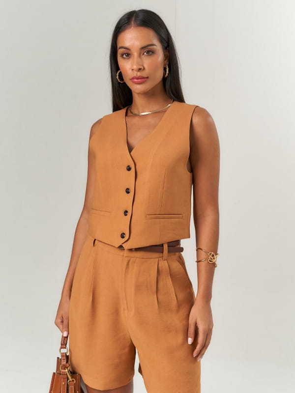 Colete alfaiataria feminino: modelo vestindo um colete feminino twill mini marrom.