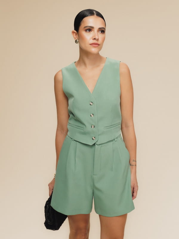 Colete alfaiataria feminino: modelo vestindo um colete feminino twill mini verde.