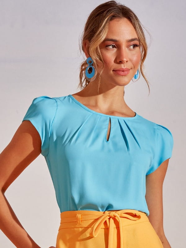 Como combinar cores de roupas: modelo vestindo uma blusa de crepe básica detalhe gota azul céu.
