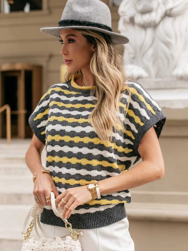 Como escolher a estampa certa e se manter elegante: modelo com um colete de tricot listrado cinza, off white e amarelo.