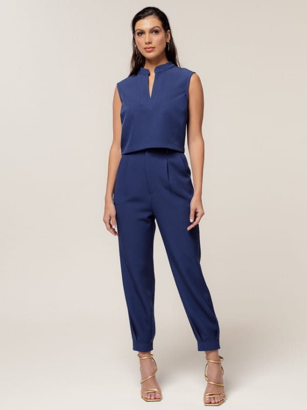Como usar calça alfaiataria: modelo vestindo uma calça alfaiataria feminina com modelagem cenoura azul.