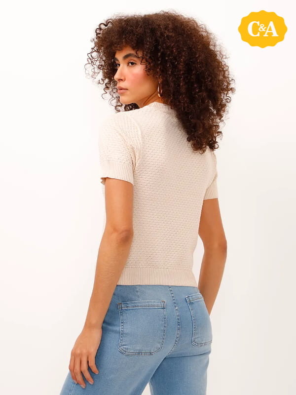 Cores que combinam com bege: modelo vestindo uma blusa de tricot manga curta texturizada bege - costas.