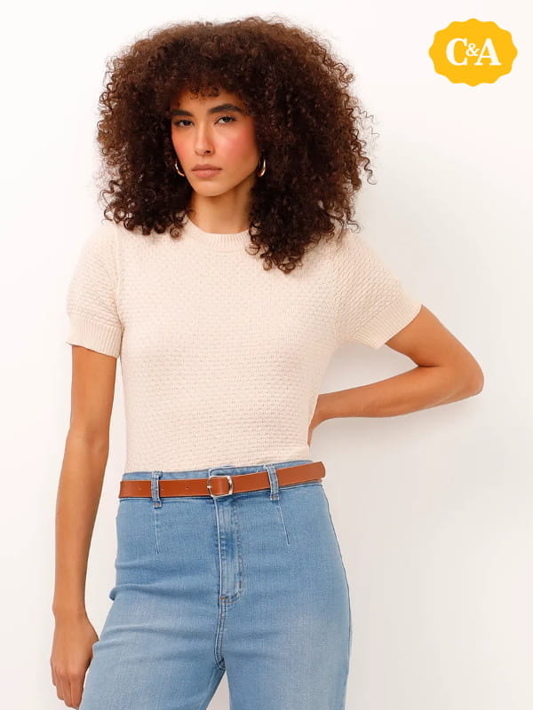 Cores que combinam com bege: modelo vestindo uma blusa de tricot manga curta texturizada bege.