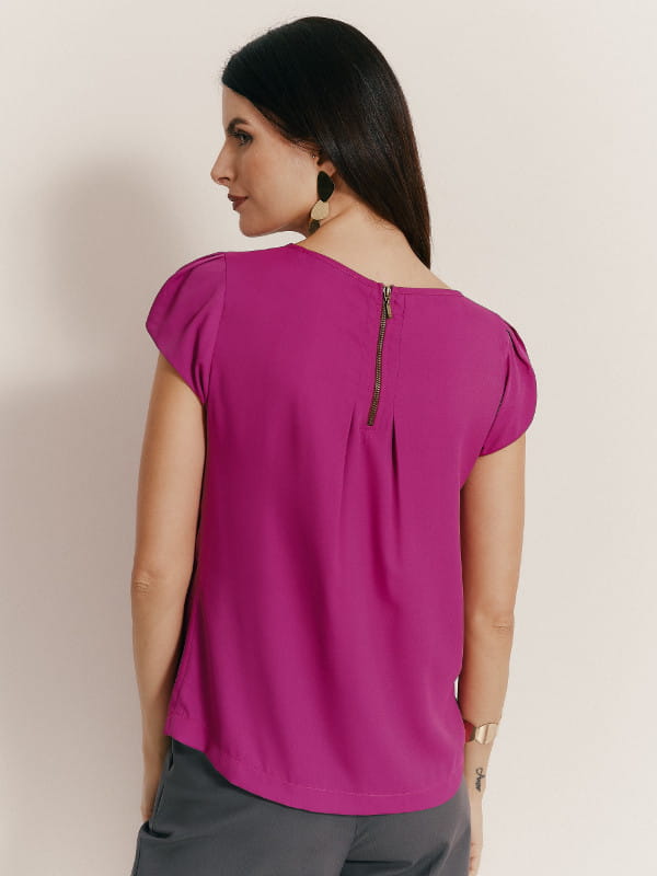 Cores que combinam com fucsia: modelo vestindo uma blusa de crepe fucsia com detalhe gota - costas.