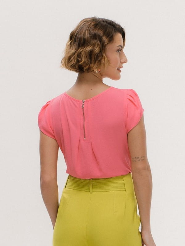 Cores que combinam com rosa: modelo vestindo uma blusa de crepe básica detalhe gota cor rosa e calça verde - costas.