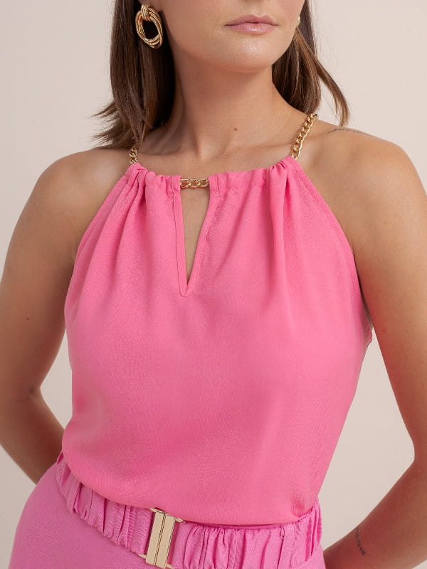 Cores que combinam com rosa: modelo vestindo uma blusa de crepe com decote corrente e saia rosa.