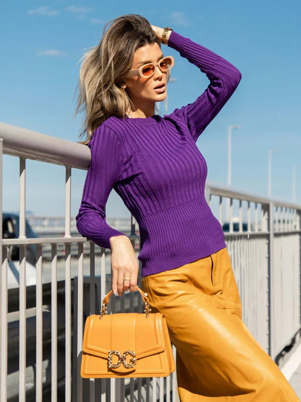 Cores que combinam com roxo: modelo vestindo uma blusa de tricot canelada roxa e saia amarela - perfil.