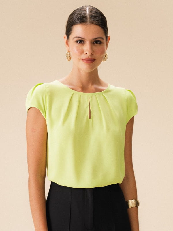 Cores que combinam com verde: modelo vestindo uma blusa de crepe básica detalhe gota cor verde lima.