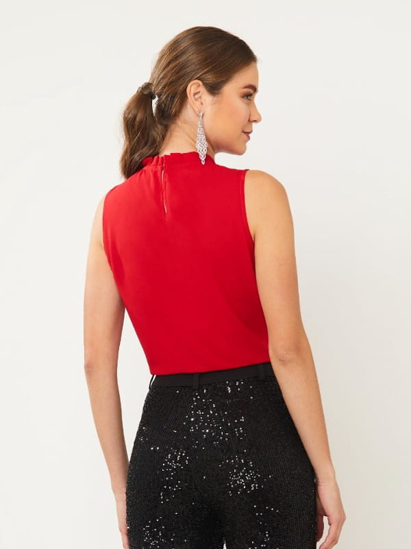 Cores que combinam com vermelho: modelo vestindo uma blusa de crepe regata vermelha com calça preta - costas.