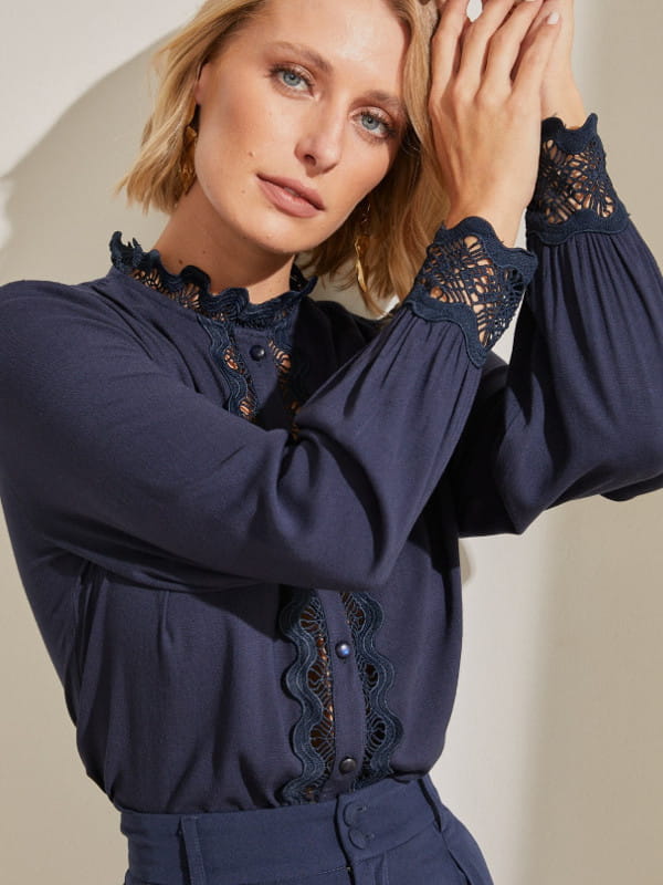 Look com camisa social feminina: modelo usando uma camisa social azul marinho.