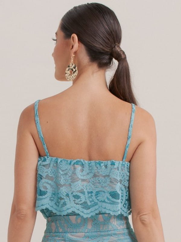 Looks com as costas a mostra: modelo com uma blusa de renda azul - costas.