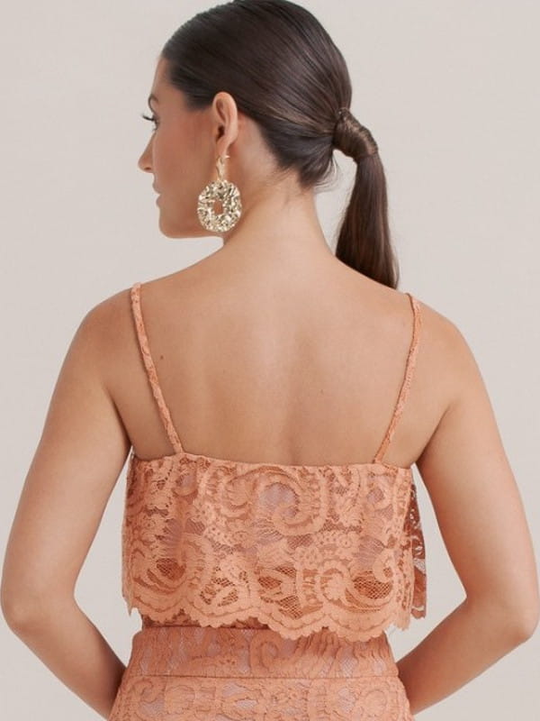 Looks com as costas a mostra: modelo com uma blusa de renda rosê - costas.