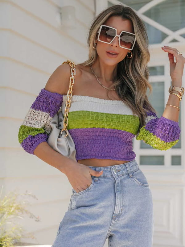 Looks com blusinha cropped: modelo vestindo uma blusa cropped de tricot listrada.