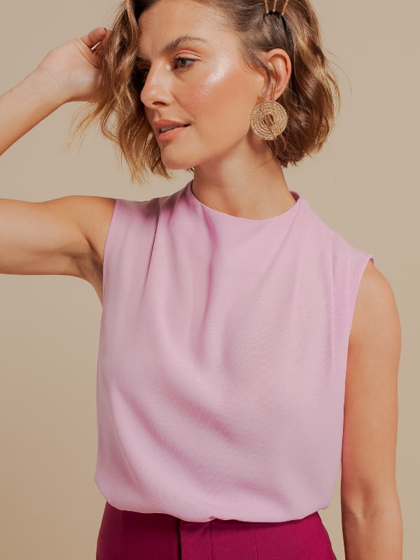 Moda e estilo: o que as cores transmitem: modelo vestindo uma blusa de crepe com pregas no ombro rosa claro.
