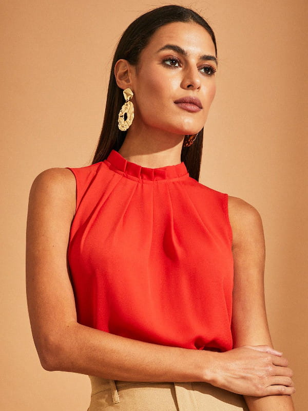 Moda e estilo: o que as cores transmitem: modelo vestindo uma blusa de crepe básica com pregas laranja.