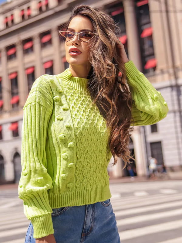 Moda Outono Inverno 2022: modelo com uma blusa de tricot feminina golinha alta verde lima.