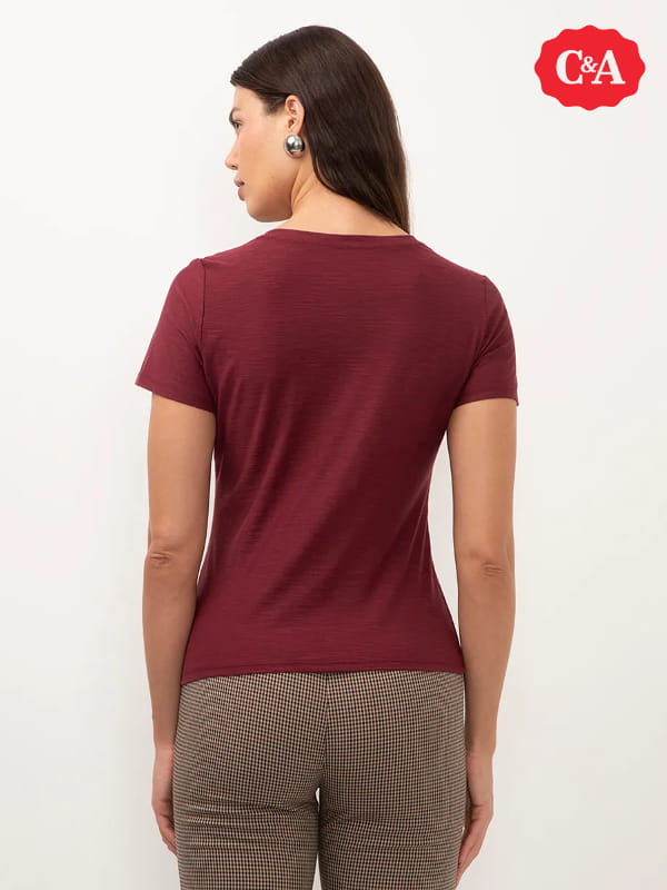 Modelos de blusas femininas: modelo vestindo uma blusa básica flamê manga curta decote V vinho - costas.